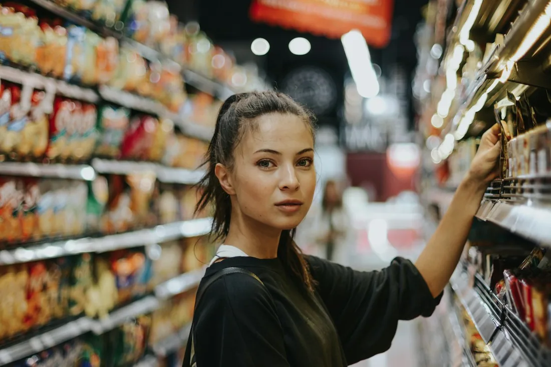 Женщина выбирает товар в продуктовом магазине